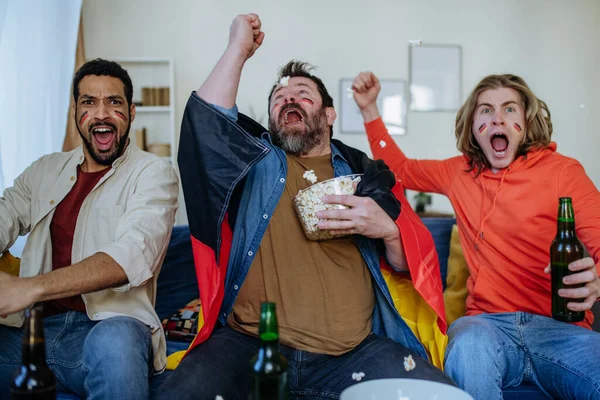 Happy German football fans friends watching football at home and celebrating — Stock Photo, Image