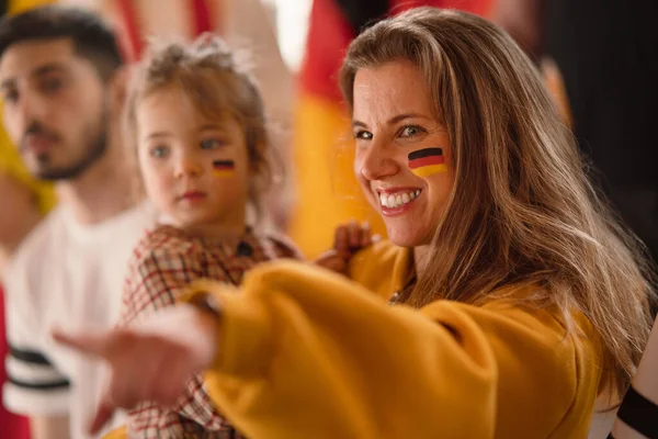 Excited football fans, mother with little daughter, supproting German national team in live soccer match at stadium. — Stock Photo, Image