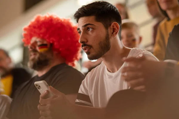 Preocupados aficionados al fútbol que apoyan a la selección alemana en un partido de fútbol en vivo en el estadio. — Foto de Stock