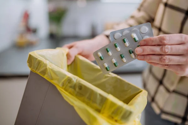 Womans hands holding and throwing expired pills to the trash bin. — Stock Photo, Image