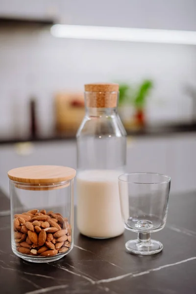 Latte di mandorla e vetro sul bancone della cucina. Concetto di prodotto vegano sano. — Foto Stock