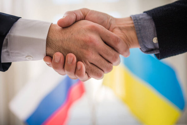 Representatives of Ukraine and Russia shaking hands, Ukraine peace agreement concept.