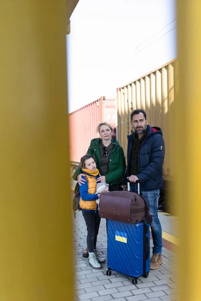 Ukrainische Flüchtlingsfamilie mit Gepäck am Bahnhof, ukrainisches Kriegskonzept. — Stockfoto