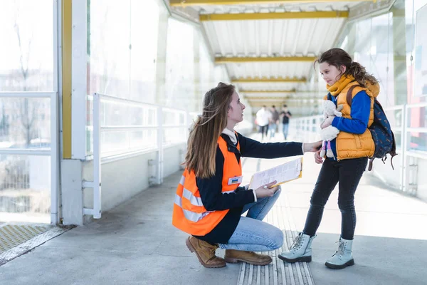 Добровольця, який допомагає українській дитині - біженцю на залізничній станції.. — стокове фото