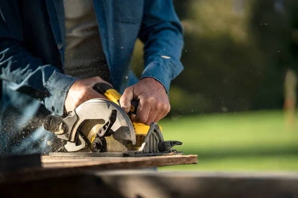 Nahaufnahme eines Flößers bei der Arbeit mit der Kreissäge auf der Baustelle — Stockfoto