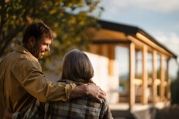 Reifes Paar betrachtet sein neues Haus im Bau, plant die Zukunft und träumt. — Stockfoto