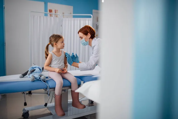 Niña preocupada vacunándose en el consultorio médico. — Foto de Stock