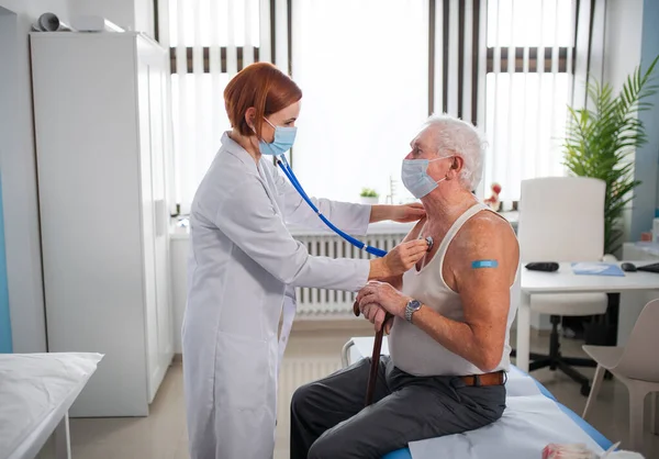 Ärztin untersucht Seniorin in ihrem Büro. — Stockfoto