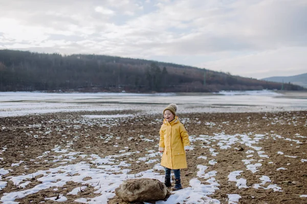 Kışın gölün kenarında koşan üzgün küçük çocuk.. — Stok fotoğraf