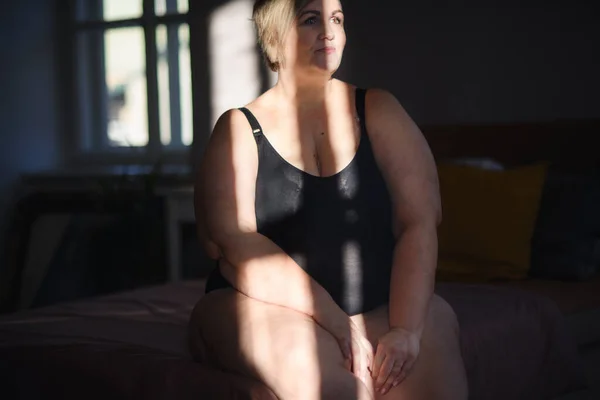 Felice donna grassa solitaria in biancheria intima rilassante a casa. — Foto Stock