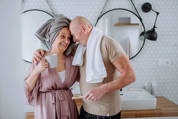 Casal de idosos apaixonados no banheiro, escovando os dentes e conversando, conceito de rotina matinal. — Fotografia de Stock