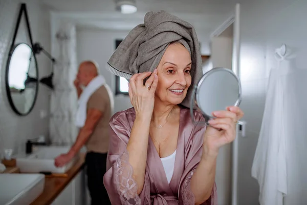Coppia anziana in bagno, lavarsi i denti e guardarsi allo specchio, concetto di routine mattutina. — Foto Stock