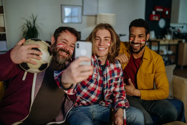 Ευτυχισμένοι φίλοι του ποδοσφαίρου βλέποντας ποδόσφαιρο στο σπίτι και βγάζοντας selfie — Φωτογραφία Αρχείου