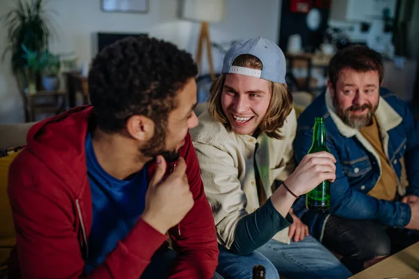 Felices amigos aficionados al fútbol viendo el fútbol en casa y hablando — Foto de Stock