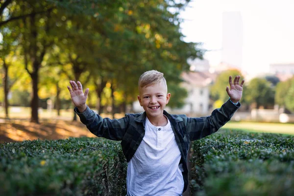 Glücklicher kleiner Junge rennt und guckt Kamera-Outfits im Park an — Stockfoto