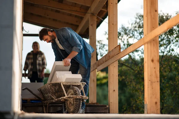 Mature couple working together on construction site of their new house. — Stock Photo, Image