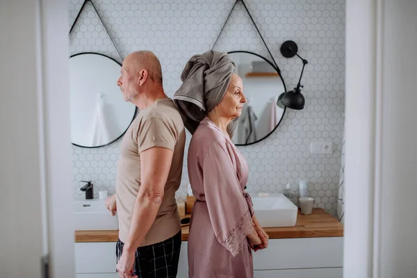 Idős pár a fürdőszobában, háttal állnak egymásnak, párkapcsolati problémák koncepciója. — Stock Fotó