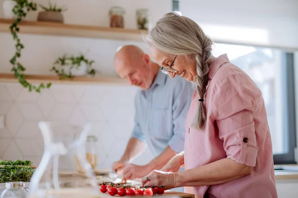 Glada äldre par matlagning tillsammans hemma. — Stockfoto