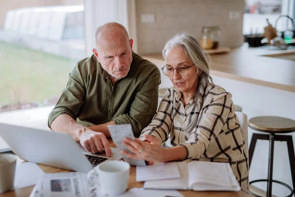 Pasangan senior yang stres menghitung biaya atau perencanaan anggaran bersama-sama di rumah. Stok Foto