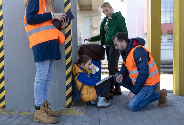 Freiwillige helfen ukrainischer Flüchtlingsfamilie am Bahnhof. — Stockfoto