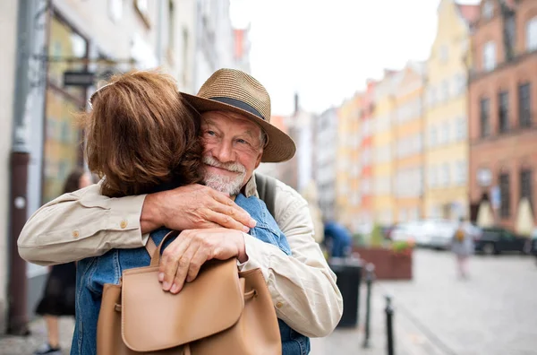 Портрет счастливой пожилой пары туристов, обнимающих на открытом воздухе в историческом городе — стоковое фото