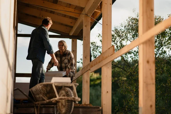 Mature couple working together on construction site of their new house. — Stock Photo, Image