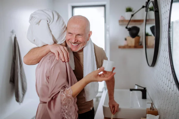 Senior couple in love in bathroom, brushing teeth and hugging, morning routine concept. — стоковое фото