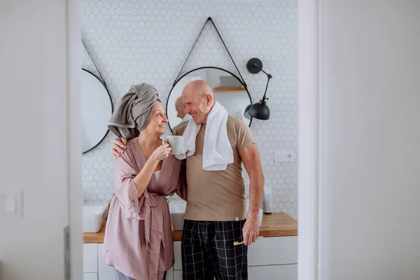 Casal de idosos apaixonados no banheiro, escovando os dentes e conversando, conceito de rotina matinal. — Fotografia de Stock