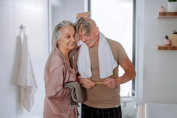 Casal sênior apaixonado no banheiro, se divertindo, conceito de rotina matinal. — Fotografia de Stock