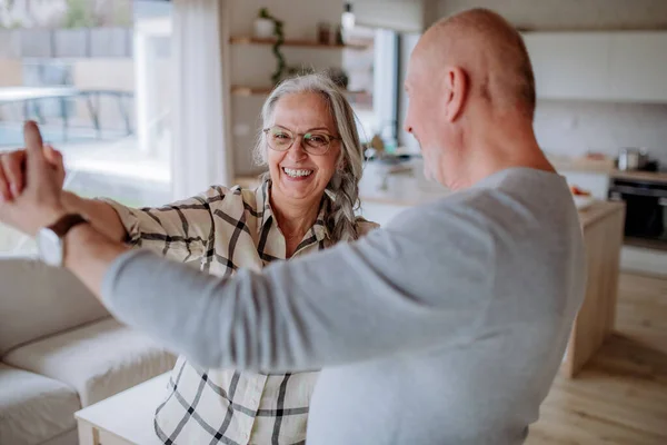Fröhliches Senioren-Paar tanzt gemeinsam zu Hause. — Stockfoto