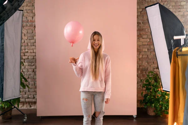 Retrato de estudio de una joven rubia feliz con globo sobre fondo rosa. —  Fotos de Stock