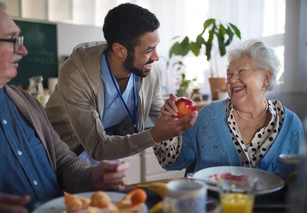 Sorridente donna anziana e uomo godendo la colazione nel centro di assistenza domiciliare. — Foto Stock