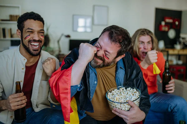 Feliz alemán fans del fútbol amigos viendo el fútbol en casa y comer palomitas de maíz. — Foto de Stock