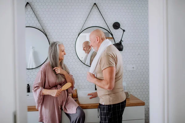 Senior couple in love in bathroom, talking, morning routine concept. — Fotografia de Stock