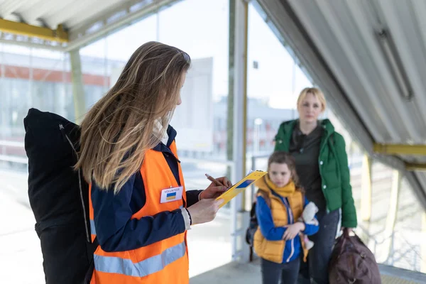 Volunteer filling form for Ukrainian refugees at train station. — Stockfoto