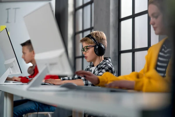 Школьные дети, использующие компьютер в классе в школе — стоковое фото