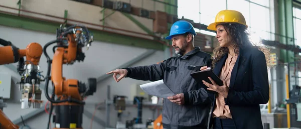 Female engineering manager and mechanic worker doing routine check up in industrial factory — Stock Fotó