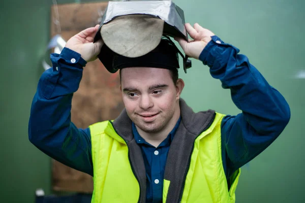 산업 공장에서 일하는 다운 증후군을 앓고 있는 젊은이, 사회 통합 개념. — 스톡 사진