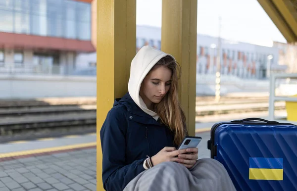 Depresyondaki Ukraynalı göçmen kadın tren istasyonunda oturuyor ve bekliyor.. — Stok fotoğraf