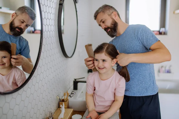 Father brushing his little daughters hair in bathroom, morning routine concept. — Foto de Stock
