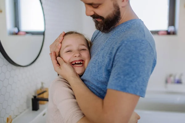 Счастливый отец обнимает свою маленькую дочь в ванной. — стоковое фото