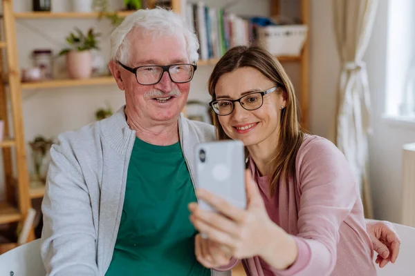 Yetişkin kız, büyük babasını evde ziyaret edip selfie çekiyor.. — Stok fotoğraf