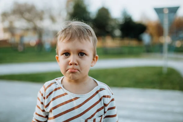 Droevig jongetje huilend buiten in het park — Stockfoto