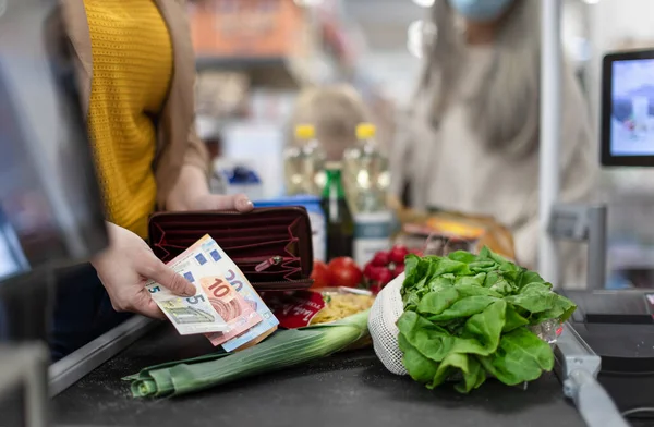 Detailní záběr ženy dávat peníze na pokladně v supermarketu — Stock fotografie