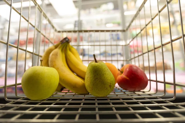 Ovoce uvnitř vozíku v supermarketu, konceptu inflace a hospodářské recese. — Stock fotografie