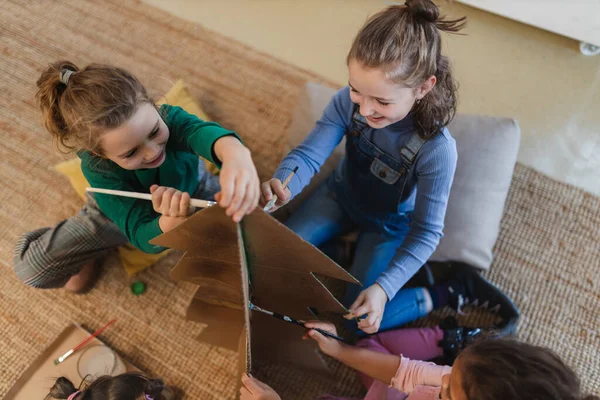 Gruppe kleiner Mädchen bemalt Pappbaum bei kreativer Kunst- und Bastelstunde in der Schule — Stockfoto