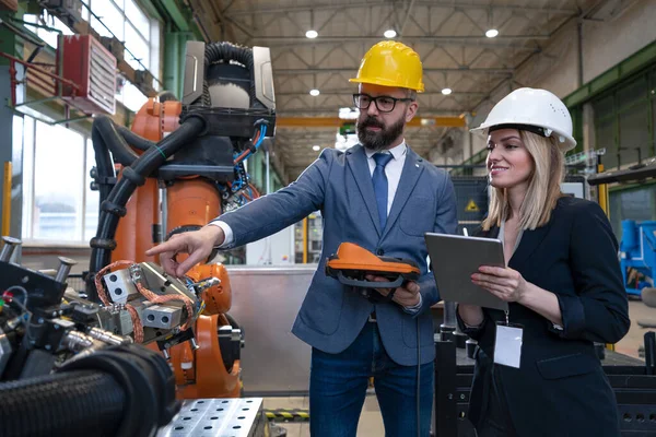 로봇팔을 사용하여 생산을 최적화하고 계획하는 현대 산업 공장의 수석 엔지니어와 프로젝트 매니저. — 스톡 사진