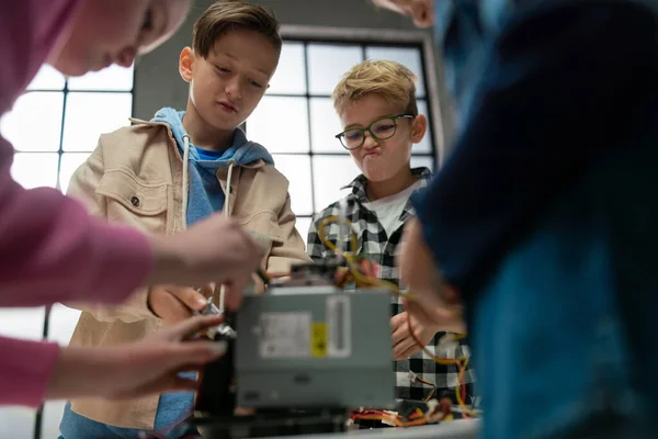 Діти з учителем працюють разом над проектом з електричними іграшками та роботами в класі робототехніки . — стокове фото
