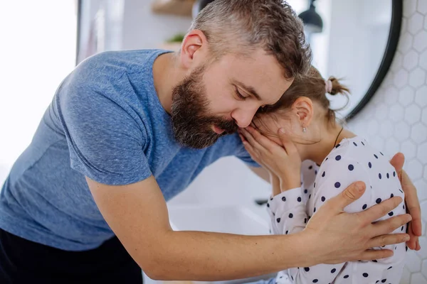 Father consoling his little upset daughter in bathroom at home. — Stock Photo, Image