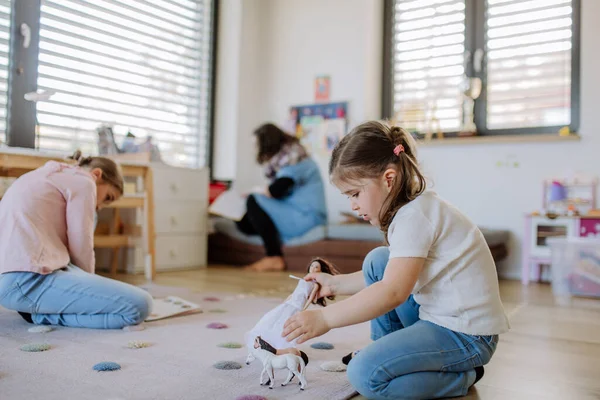 Cheerful little sisters playing at home with toys. — Fotografia de Stock